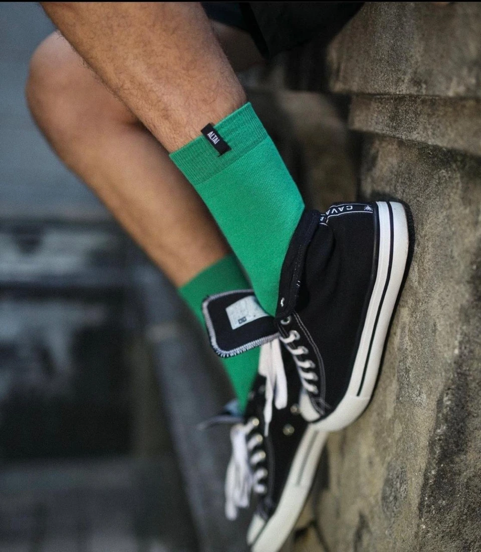 Detalhe das meias verdes Altai em um look com tênis preto